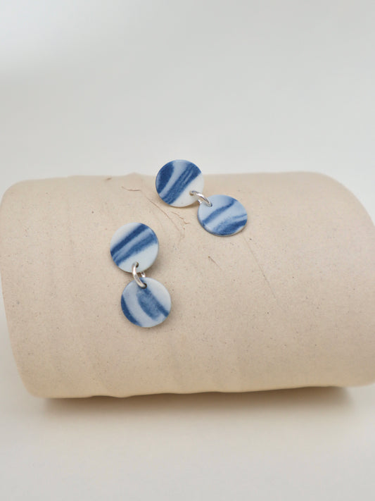 A pair of small hand-marbled cobalt blue and white porcelain double disc drop earrings connected by sterling silver jump rings