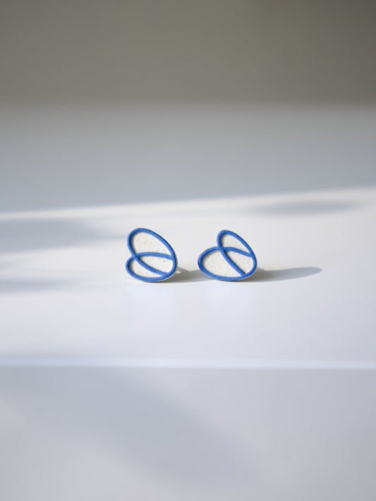 Natural stoneware stud earrings with an interlocking blue loop design.